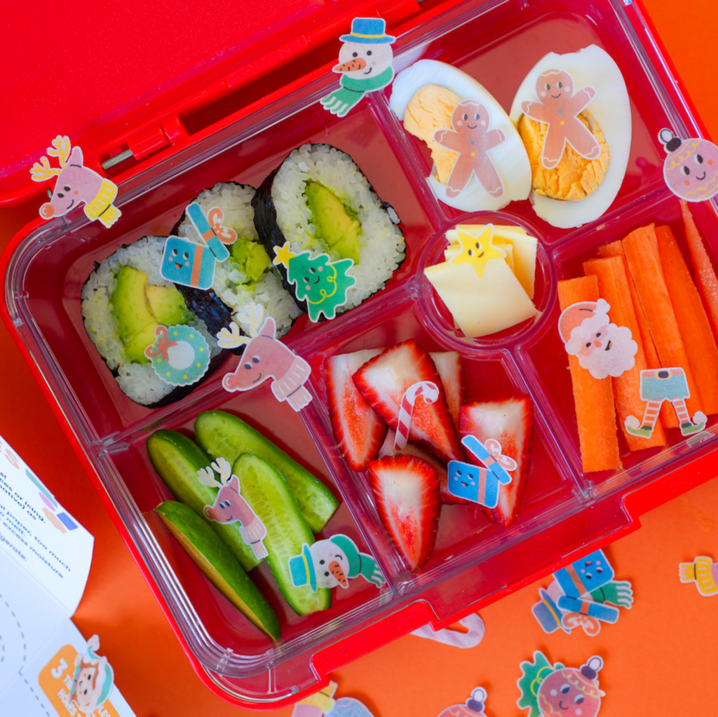 kids bento box lunch with sushi, egg, fruit and vegetables. Decorated with Merry Sticks to create a Christmas themed lunchbox