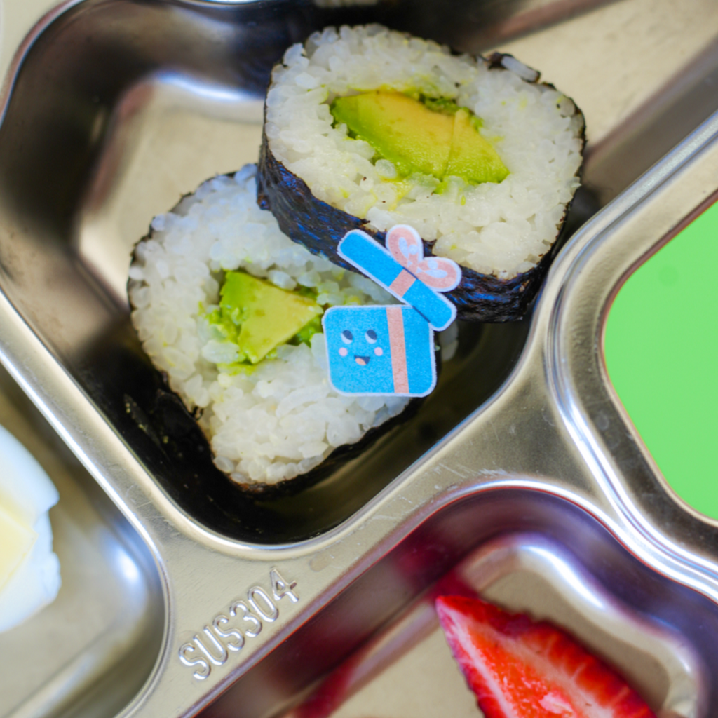 Christmas bento accessories. Christmas themed edible stickers decorating sushi in a stainless steel lunch plate for kids